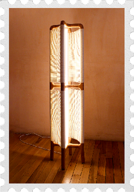 a tall wooden floor lamp glowing in a warm room